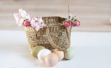 Sade tavuk yumurtaları, yumuşak pastel renkler, doğal renkte tavuk yumurtaları, hasır sepette yumurtalar, Paskalya konsepti, bahar
