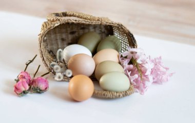 Sade tavuk yumurtaları, yumuşak pastel renkler, doğal renkte tavuk yumurtaları, hasır sepette yumurtalar, Paskalya konsepti, bahar