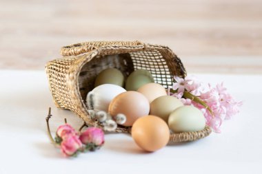 Sade tavuk yumurtaları, yumuşak pastel renkler, doğal renkte tavuk yumurtaları, hasır sepette yumurtalar, Paskalya konsepti, bahar