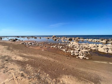 Güneşli deniz manzarası, mavi gökyüzü, deniz kıyısında birçok taş, Vidzeme kayalık kıyısı, Letonya