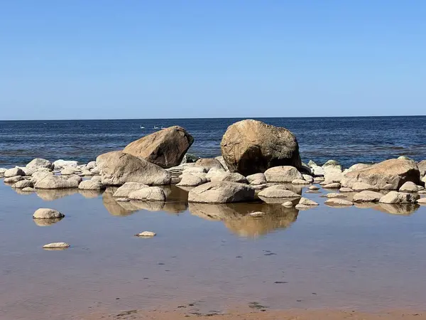 stock image sunny view of the sea, blue sky, many stones on the seashore, Vidzeme rocky seashore, Latvia