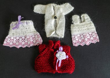 Farklı renkler örülmüş bebek kıyafetleri, küçük kız için sevimli bebek kıyafetleri koleksiyonu.