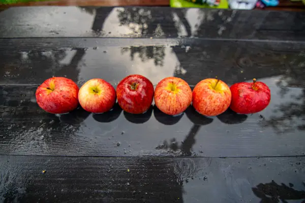Rijpe Rode Appels Een Natte Houten Tafel Reflecties Van Appels — Stockfoto