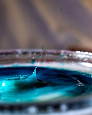 Renkli damlası olan soyut resim, bulanık arkaplan, su damlası sıçraması, yakın odak, kumlu su dokusu