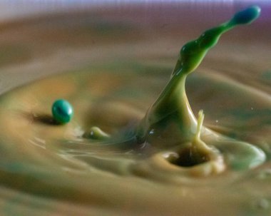 Renkli damlası olan soyut resim, bulanık arkaplan, su damlası sıçraması, yakın odak, kumlu su dokusu