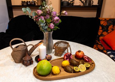 Beyaz mum, kuru çiçekler, meyveler ve diğer nesnelerle dolu durgun bir hayat, neşeli bir iç mekan.