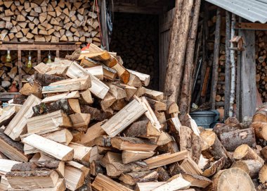 Bahçedeki odun yığınları, kış mevsimi için odun işleme, yakıt ikmali, kırsal alanda odun ısıtma.