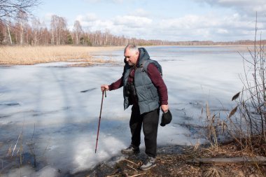 Baharda bataklık gölü, bahar manzarası, gölün kıyısındaki adam, yapraksız ağaçlar, bahar