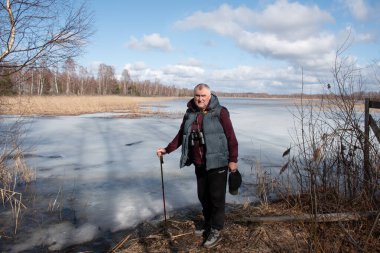 Baharda bataklık gölü, bahar manzarası, gölün kıyısındaki adam, yapraksız ağaçlar, bahar