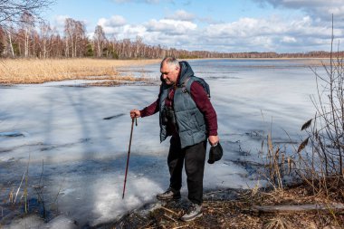 Baharda bataklık gölü, bahar manzarası, gölün kıyısındaki adam, yapraksız ağaçlar, bahar
