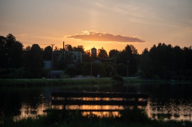 Renkli gün doğumu, göl kenarındaki günbatımı manzarası, parlak renkli gökyüzü gölün suyuna yansıyor, Mazais Ansis, Rubene, Letonya