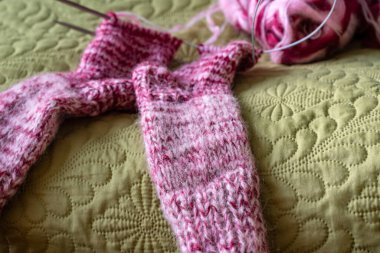 Örgü çoraplar, renkli iplik ve iğneler, sihirli döngü tekniğinde örülmüş, el yapımı.