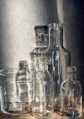 Cam şişeli sakin bir hayat, arka planda sessiz gölgeler, yumuşak akşam ışığı, bulanık bir arka plan.