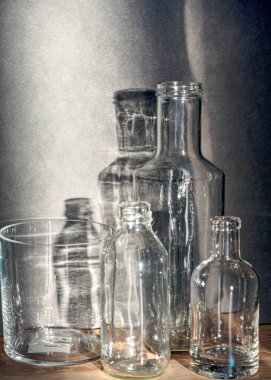 Cam şişeli sakin bir hayat, arka planda sessiz gölgeler, yumuşak akşam ışığı, bulanık bir arka plan.