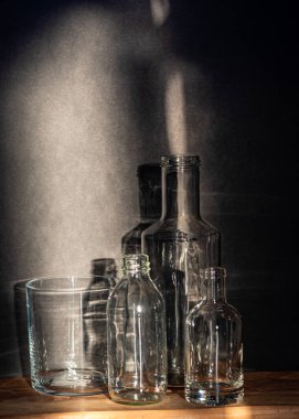 Cam şişeli sakin bir hayat, arka planda sessiz gölgeler, yumuşak akşam ışığı, bulanık bir arka plan.