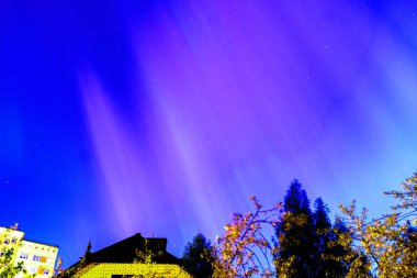 Evin çatısında muhteşem kuzey ışıkları olan manzara, parlak renkli aurora, bahar