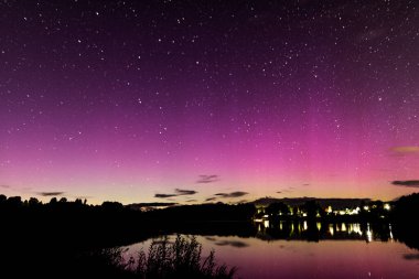 Gökyüzünde kuzey ışıkları olan güzel gece manzarası, göldeki yansıma, Mazais Ansis, Rubene, Letonya