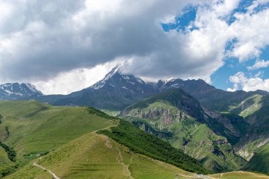 güzel dağ manzarası, bulutlar dağ zirvelerini kaplıyor, Kazbek, Georgia, yaz