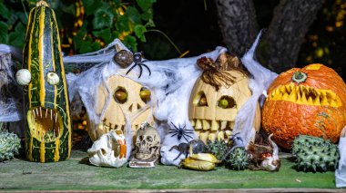 Alışılmadık orjinal Cadılar Bayramı kompozisyonu, korkutucu Jack O Lantern Cadılar Bayramı balkabakları, farklı yüzlerle oyulmuş balkabakları farklı Cadılar Bayramı süslemeleriyle çevrili.