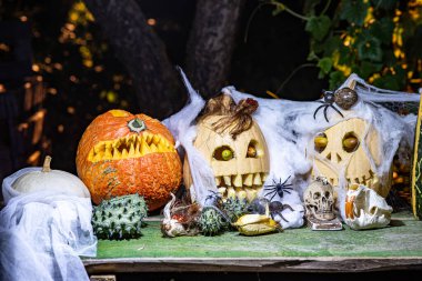 Alışılmadık orjinal Cadılar Bayramı kompozisyonu, korkutucu Jack O Lantern Cadılar Bayramı balkabakları, farklı yüzlerle oyulmuş balkabakları farklı Cadılar Bayramı süslemeleriyle çevrili.