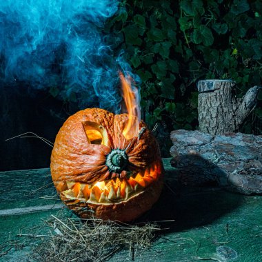 Cadılar Bayramı, karanlık arka planda korkunç bir yüzü olan yanan bir balkabağı, dışarı çıkan gri duman, Cadılar Bayramı zamanı, bir grup korkutucu balkabağı, sonbahar