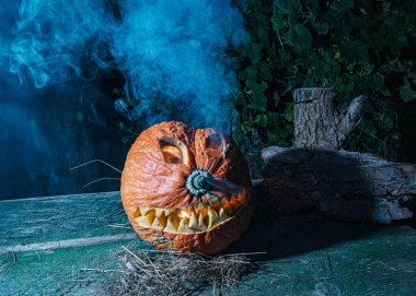 Cadılar Bayramı, karanlık arka planda korkunç bir yüzü olan yanan bir balkabağı, dışarı çıkan gri duman, Cadılar Bayramı zamanı, bir grup korkutucu balkabağı, sonbahar