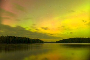 Gökyüzünde güzel kuzey ışıkları olan renkli fotoğraf gölün üzerinde kuzey ışıkları, Vaidavas Gölü, Letonya