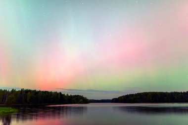 Gökyüzünde güzel kuzey ışıkları olan renkli fotoğraf gölün üzerinde kuzey ışıkları, Vaidavas Gölü, Letonya