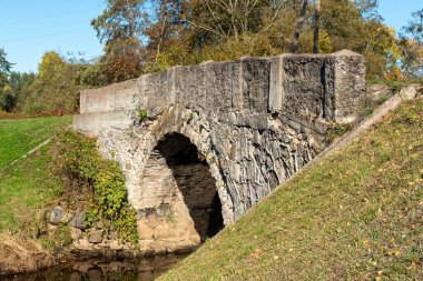 Vidagas, Vidagas köyü yakınlarındaki Vizla üzerinde taş kemerli bir köprüyle sonbahar manzarası, Letonya, sonbahar