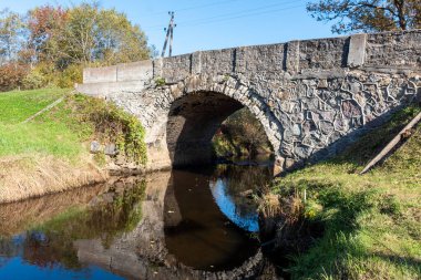 Vidagas, Vidagas köyü yakınlarındaki Vizla üzerinde taş kemerli bir köprüyle sonbahar manzarası, Letonya, sonbahar