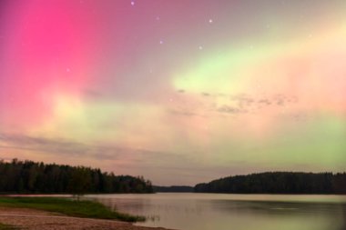Gökyüzünde güzel kuzey ışıkları olan renkli fotoğraf gölün üzerinde kuzey ışıkları, Vaidavas Gölü, Letonya