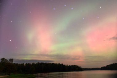 Gökyüzünde güzel kuzey ışıkları olan renkli fotoğraf gölün üzerinde kuzey ışıkları, Vaidavas Gölü, Letonya