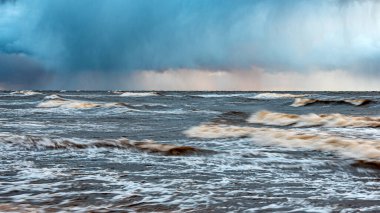 dramatic storm in the Baltic Sea, large waves crashing against the shore, blurred, unclear contours, rocky shore of Vidzeme, Thuja, Latvia clipart