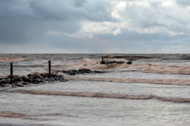Baltık Denizi 'nde dramatik bir fırtına, taş iskeleye çarpan büyük dalgalar, bulanık, belirsiz hatlar, Vidzeme, Thuja, Letonya' nın kayalık kıyıları