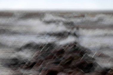 dramatic storm in the Baltic Sea, large waves crashing against the stone pier, blurred, unclear contours, rocky shore of Vidzeme, Thuja, Latvia clipart