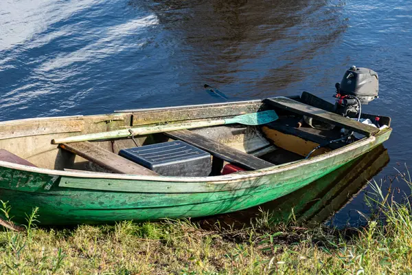 Göl kıyısındaki tekne, fırtına sırasında, su ve çimen hatlarını bulanıklaştırdı, Burtnieki Gölü, Letonya
