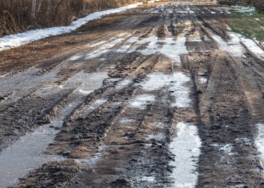 Çamurlu, ıslak bir yolu olan manzara, çamur dokusu, kar kalıntıları, kış yolu