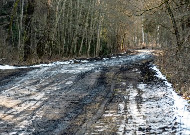 Çamurlu, ıslak bir yolu olan manzara, çamur dokusu, kar kalıntıları, kış yolu