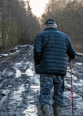 Çamurlu, ıslak bir yolda yürüyen adam, çamur dokusu, kar kalıntıları, kış yolu.