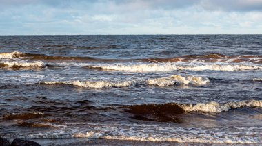 Deniz kıyısında kış manzarası, rüzgarlı kış günü, su damlaları, deniz kıyısında buzlu taşlar, Baltık Denizi, Letonya