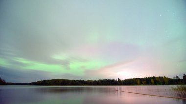 Gökyüzünde güzel kuzey ışıkları olan renkli fotoğraf gölün üzerinde kuzey ışıkları, Vaidavas Gölü, Letonya