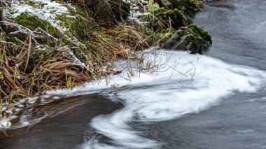 Hızlı nehir akışıyla kış manzarası, bulanık su yüzeyi, bulanık hareket, vahşi nehrin hızlı akışı, Letonya