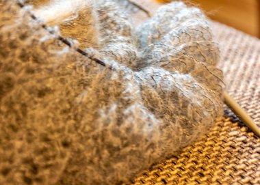 unfinished knitting, cozy, homely atmosphere, women's hobby knitting, yarn in warm colors, close-up with yarn, needles and unfinished needlework