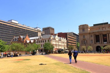 29 Eylül 2022 - Güney Afrika 'da Pretoria: Kilise Meydanı, Gündüzleri insanlar, şehrin merkezindeki çimlerin üzerinde yürüyor veya dinleniyorlar