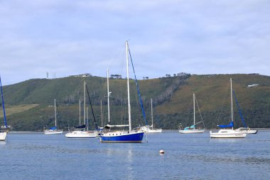 Knysna Gölü 'ndeki tekneler Knysna Tepeleri' ne, Güney Afrika 'daki Bahçe Yolu' na bakıyor.