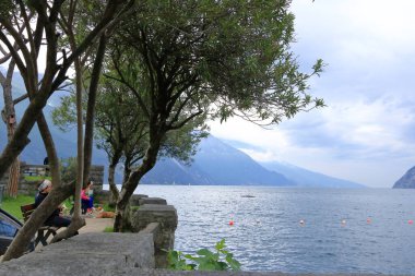19 Mayıs 2023 - İtalya 'da Riva del Garda: bulutlu bir günde şehrin limanındaki insanlar