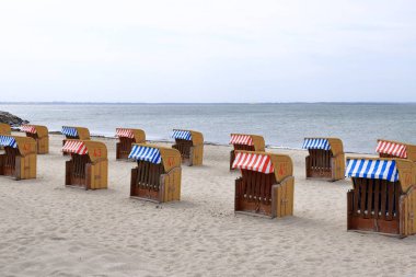Timmendorf, Almanya 'da Baltık Denizi' nde kapüşonlu plaj sandalyeleri.