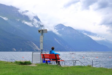 19 Mayıs 2023 - İtalya 'da Riva del Garda: bulutlu bir günde şehrin limanındaki insanlar