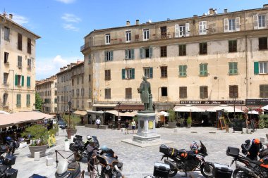 27 Mayıs 2023 - Corte, Fransa Korsika Adası: Korsika 'nın Corte şehrinin tarihi şehir merkezinde yürüyen turistler dağlarla çevrili