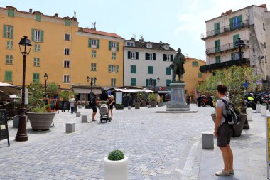 27 Mayıs 2023 - Corte, Fransa Korsika Adası: Korsika 'nın Corte şehrinin tarihi şehir merkezinde yürüyen turistler dağlarla çevrili